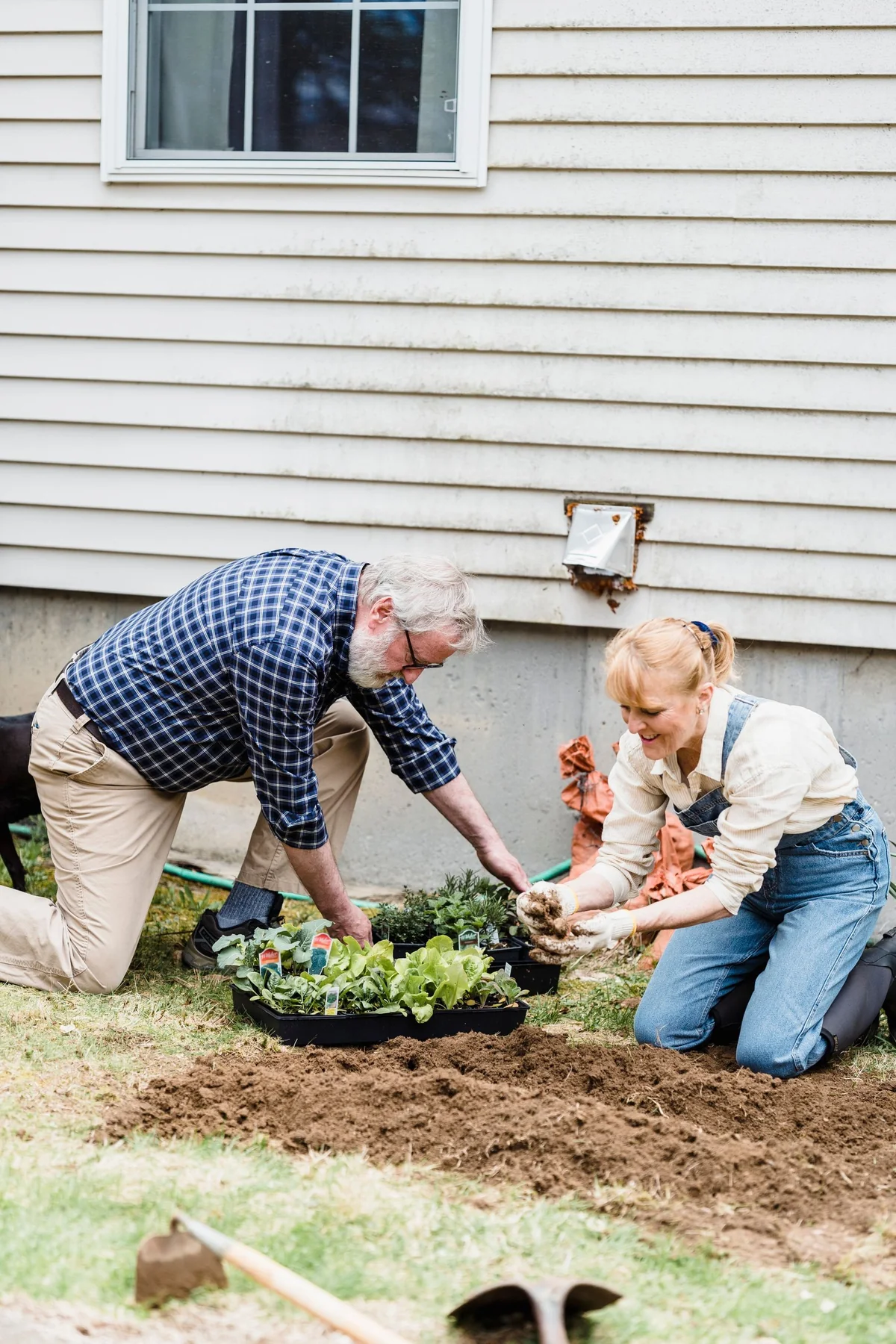 An older couple tending plants together