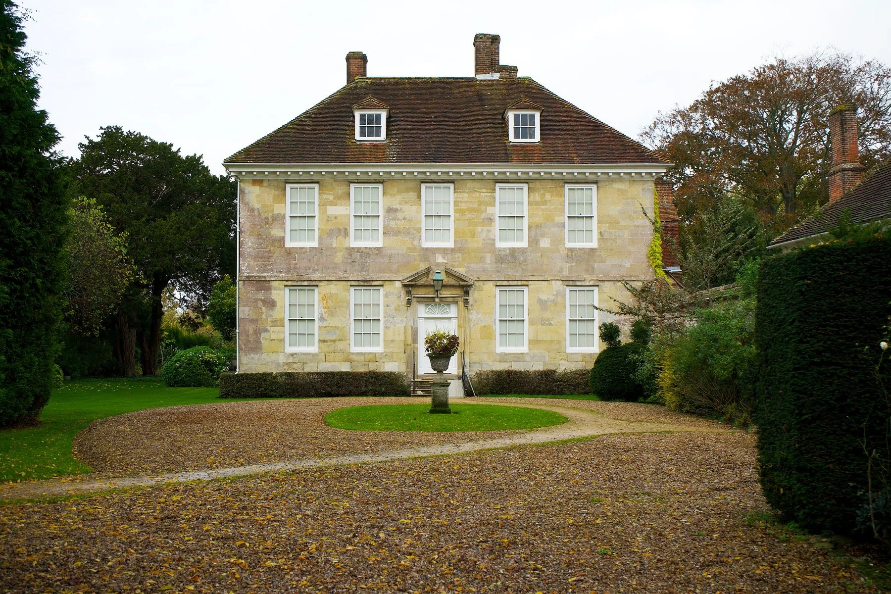 A stone country house approached by a garden path